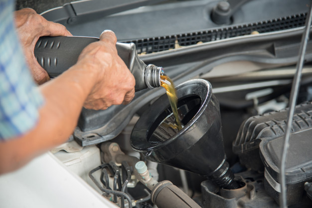 mecanico-que-drena-aceite-motor-automovil-cambio-aceite-tienda-automoviles_28989-102