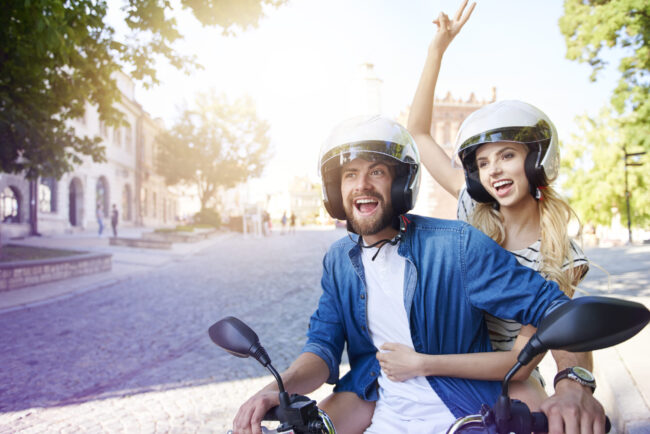 Couple riding a motorbike wearing helmets